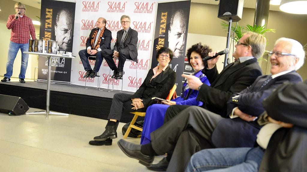 Jääkiekkopersoona Juhani Tamminen (2. vas.) kirjansa Don Tami - My Story lehdistötilaisuudessa Helsingissä 22. lokakuuta 2013. Vasemmalla on jääkiekkoselostaja Antero Mertaranta, joka juonsi tilaisuuden, ja etualla keskellä istuu Lenita Airisto.