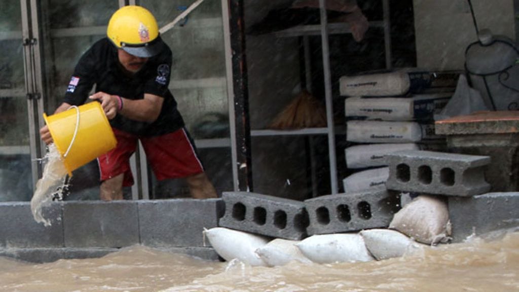 Thaimaalaismies taistelee tulvavesiä vastaan Koh Samuilla 28.3.2011.