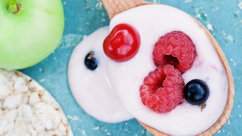 Moni herkuttelee rasvatonta jogurttia marjojen seurana.