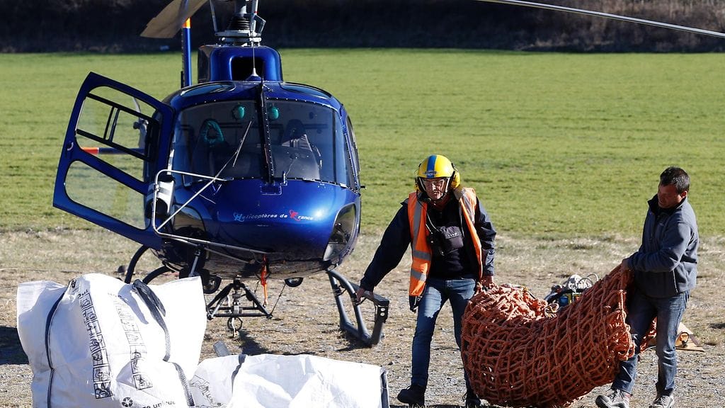 Työntekijät pakkasivat tarvikkeitaan helikopterikyytiin kuljetettavaksi turmapaikalle.