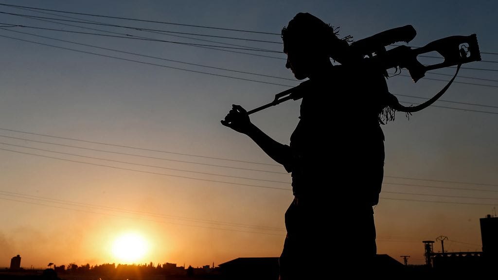 Kurditaistelija vartioi Tel Abyadin rajaporttia Pohjois-Syyriassa kesäkuussa.