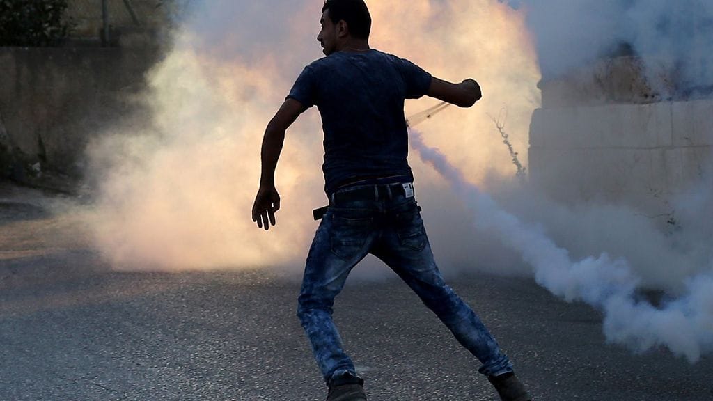 Tuoreimmat väkivaltaisuudet leimahtivat tällä viikolla. Kuvassa palestiinalainen mies uhmaa israelilaisia sotilaita 31.7.2015 lähellä Jalazounin palestiinalaista pakolaisleiriä.