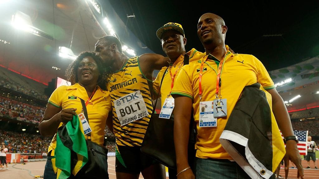 Usain Bolt juhli äitinsä Jenniferin (vas.) ja isänsä Wellesleyn (toinen oik.) kanssa MM-kultaansa.
