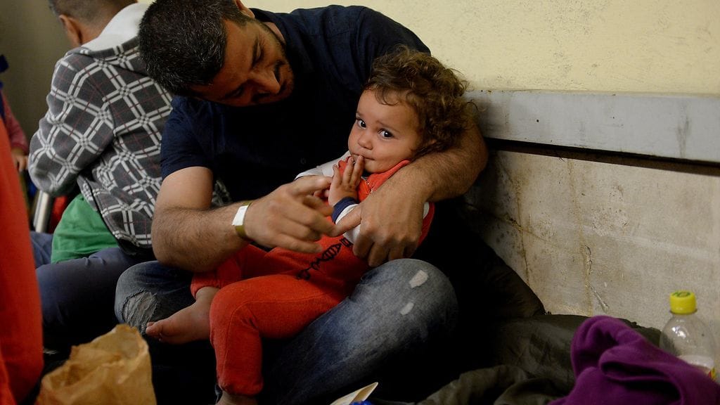 Mies ja lapsi juna-asemalla Itävallassa tänä aamuna.