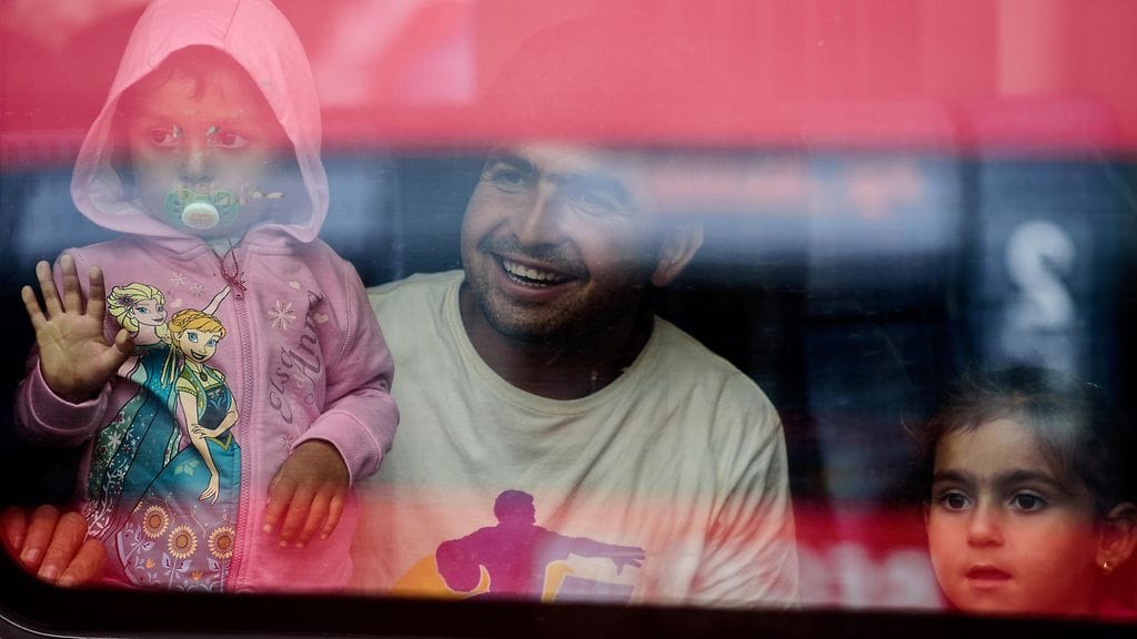 Pakolaisperhe katsoo junan ikkunasta Münchenin keskusasemalla 5.9.2015.