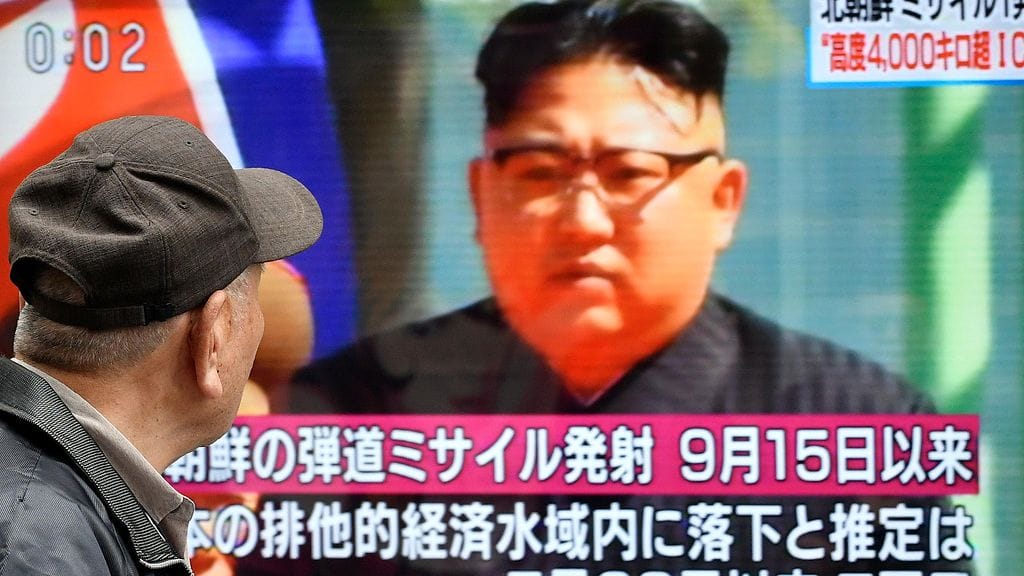 Jalankulkija Pohjois-Korean syyskuisesta ohjuskokeesta kertovan videotaulun äärellä.