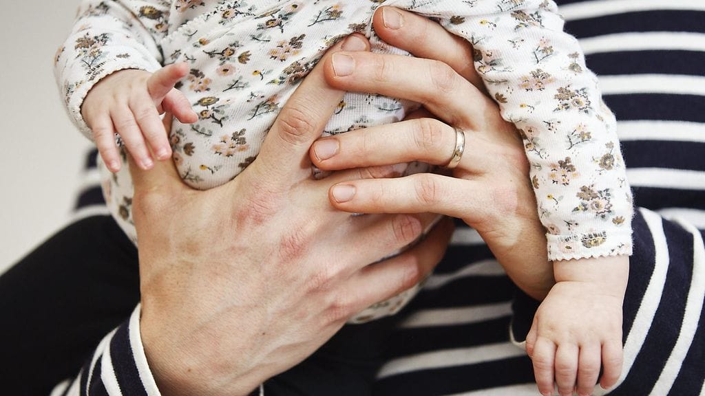 Isä ja puolivuotias lapsi leikkivät kotonaan.