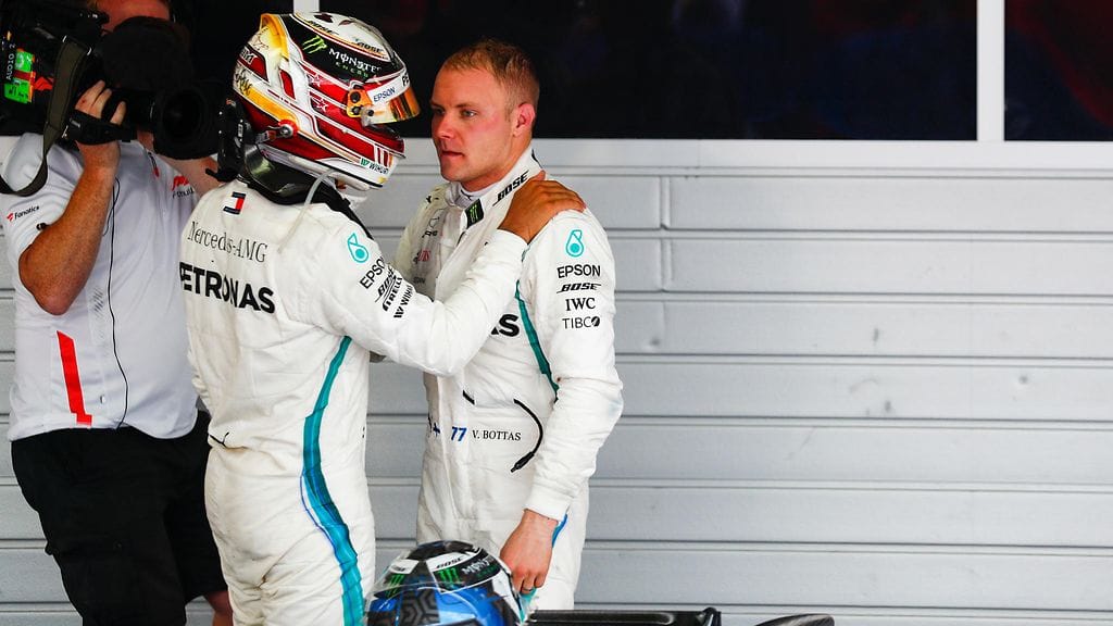 Lewis Hamilton tsemppasi Valtteri Bottasta tallimääräyksen jälkeen Sotshissa 2018.