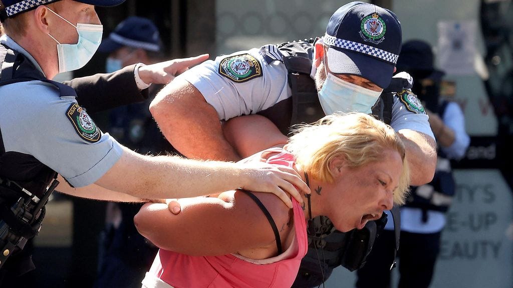 Poliisit taluttivat koronasulkua vastustavaa mielenosoittajaa poliisiautoon Melbournessa 21. elokuuta.