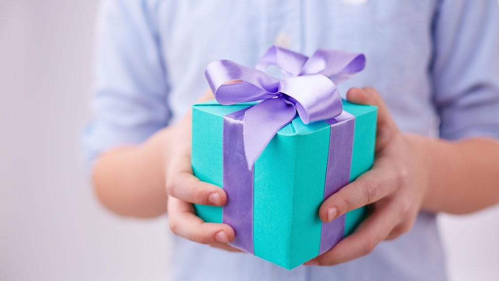 pikkupoika lahjapaketti kädessä