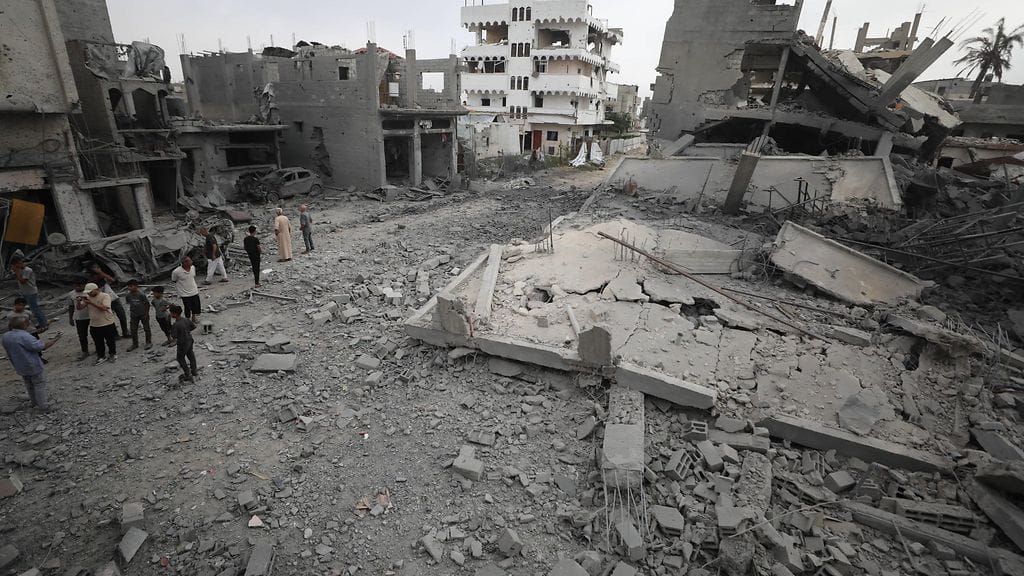 Palestiinalaiset tarkastelevat tuhoja pakolaisleirillä Gazan keskiosassa Israelin ilmaiskun jälkeen.